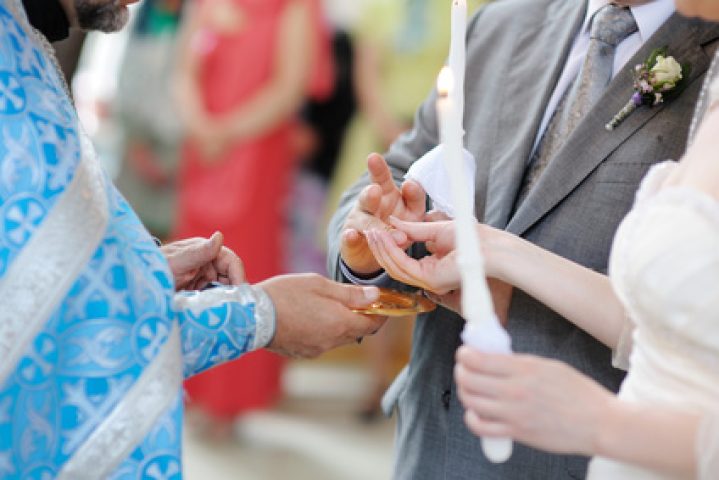 Bride putting a wedding ring on groom's finger